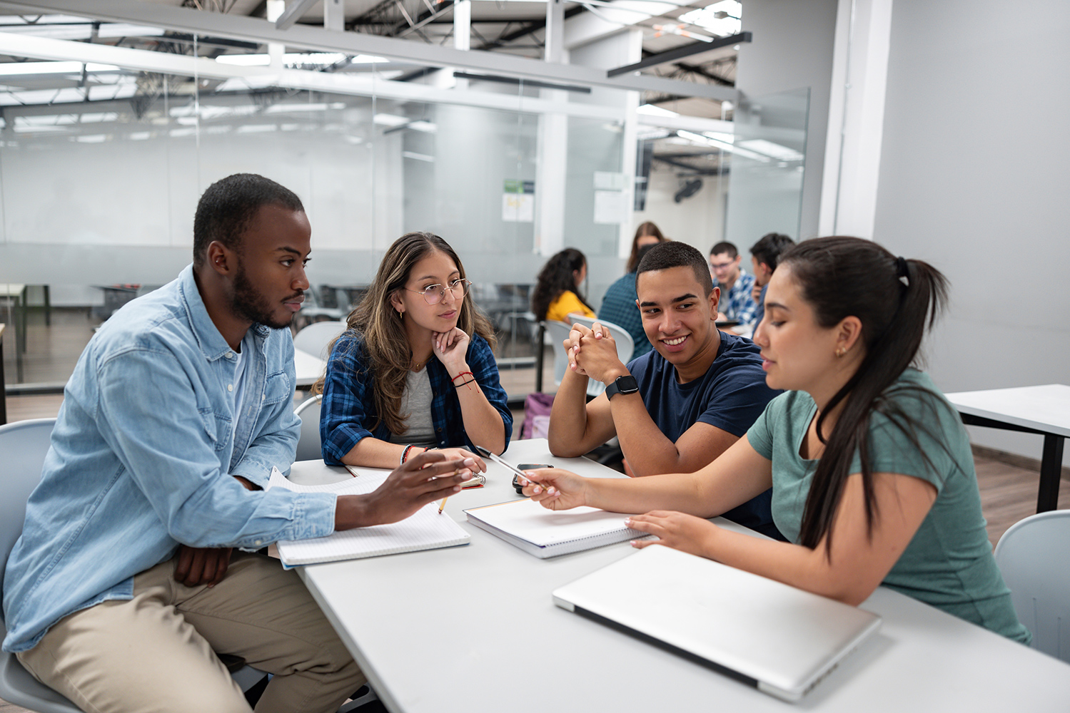 A group of college students having a discussion in a classroom.