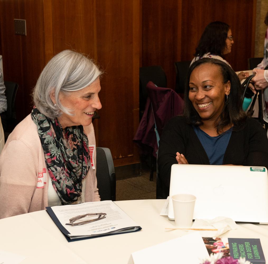 Two people in conversation at convening on educator preparation