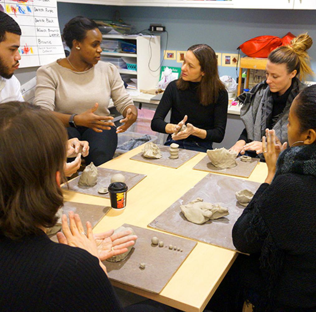 group of adults working on a project with modeling clay