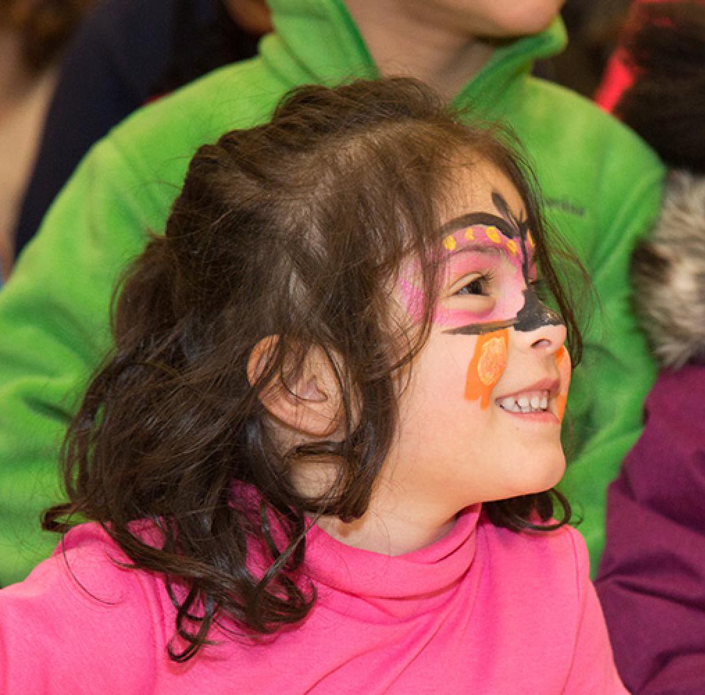Elementary aged girl with a colorful face painting