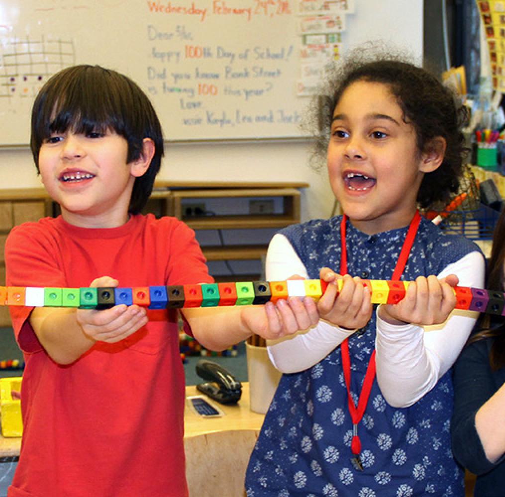 Elementary aged students holding a chain of blocks