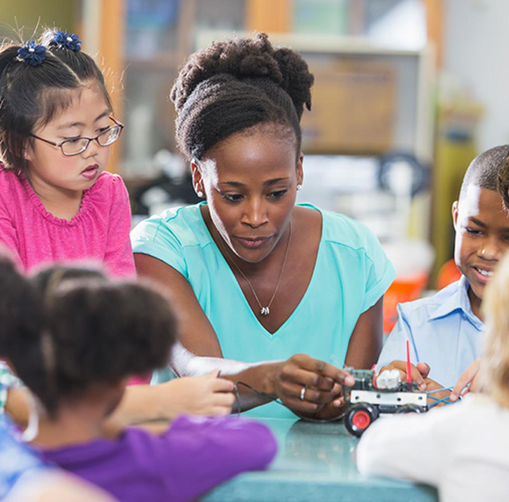 Teacher working at a table with elementary aged students