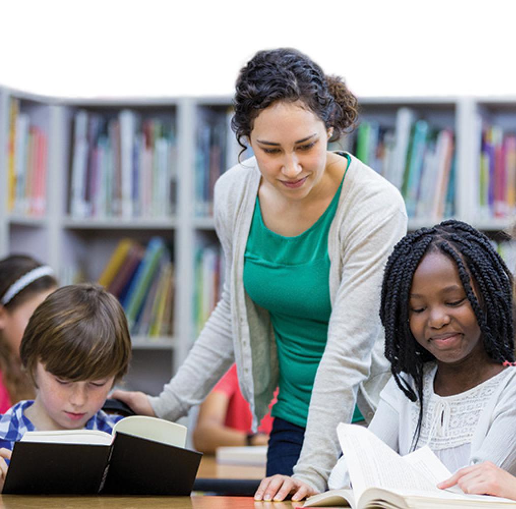 Teacher in classroom helping students at a table