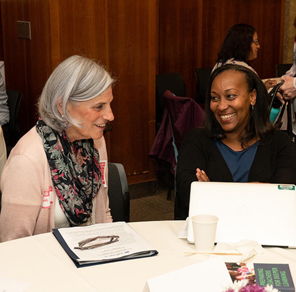 Two people in conversation at convening on educator preparation