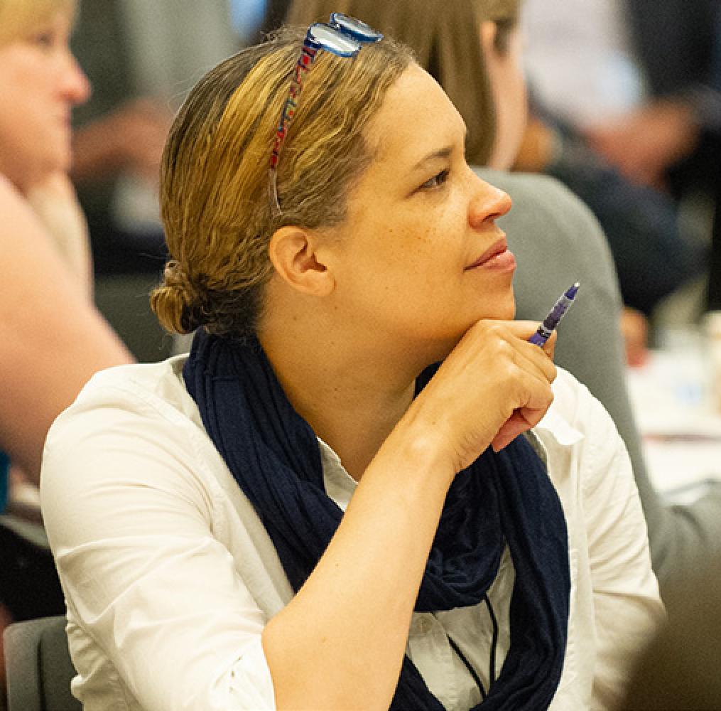 Woman seated and listening to a presentation