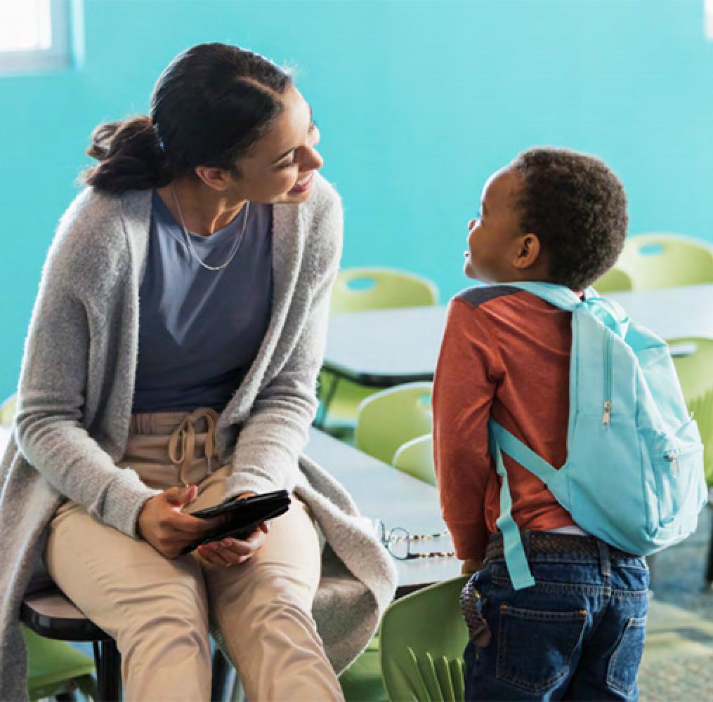 Female teacher talking with elementary-aged boy