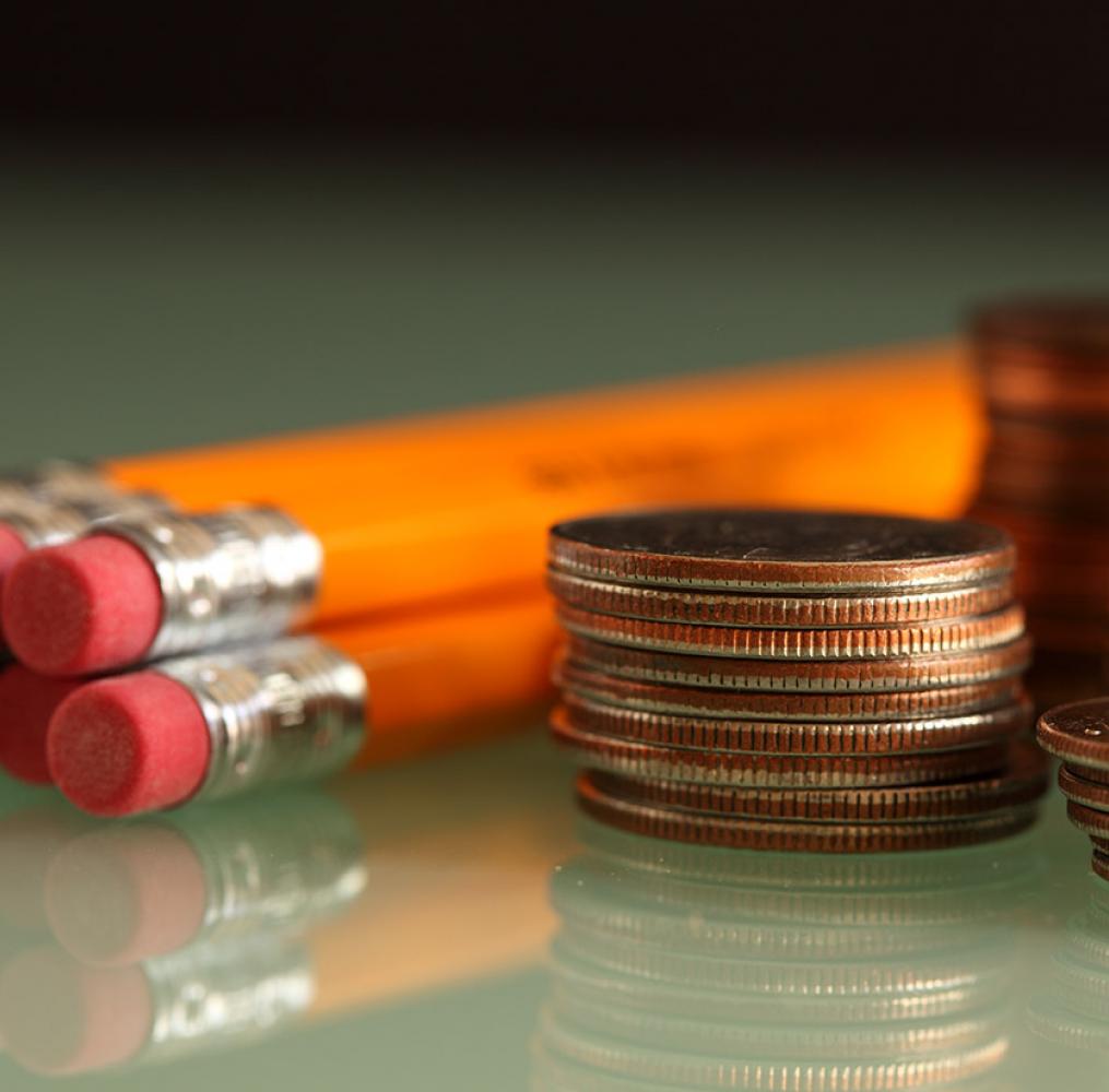 Pencils and coins on a table.