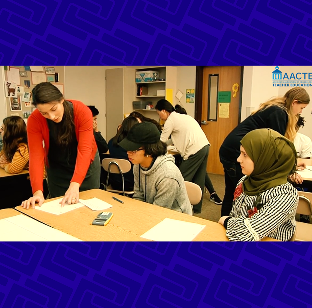 Teacher talking to students at a school desk.