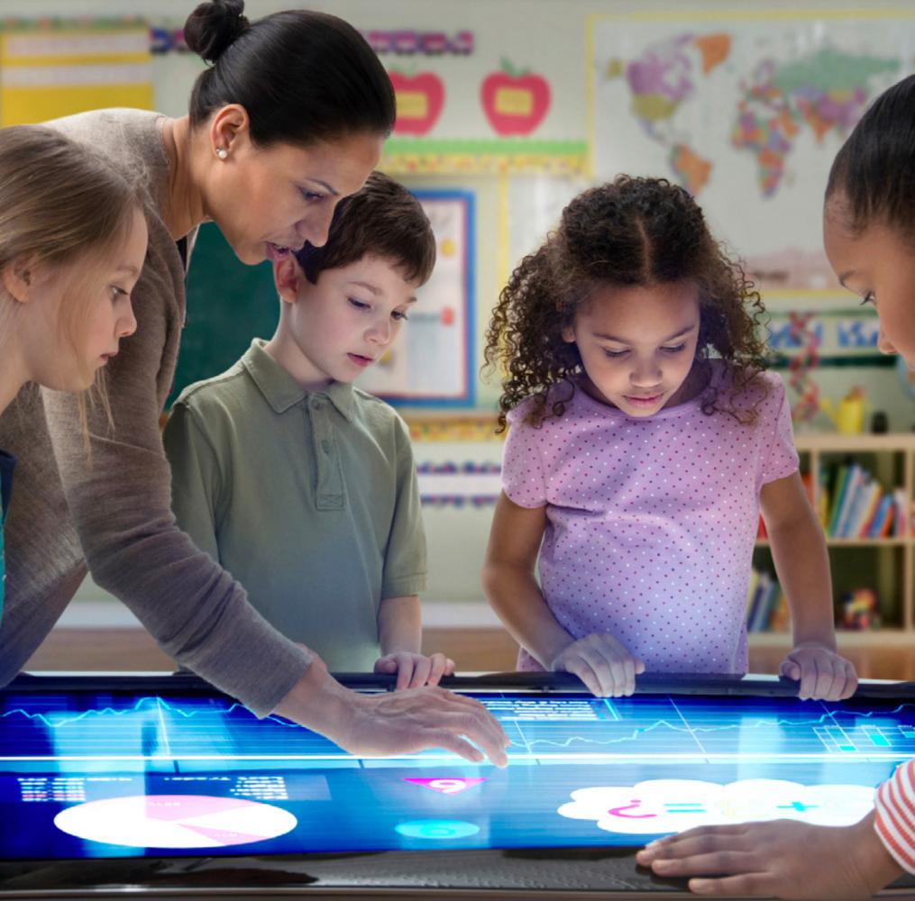 Teacher and students working on a project on an interactive screen.