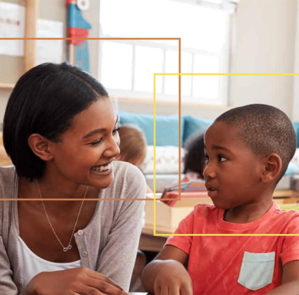 Woman and a boy smiling in a school setting.