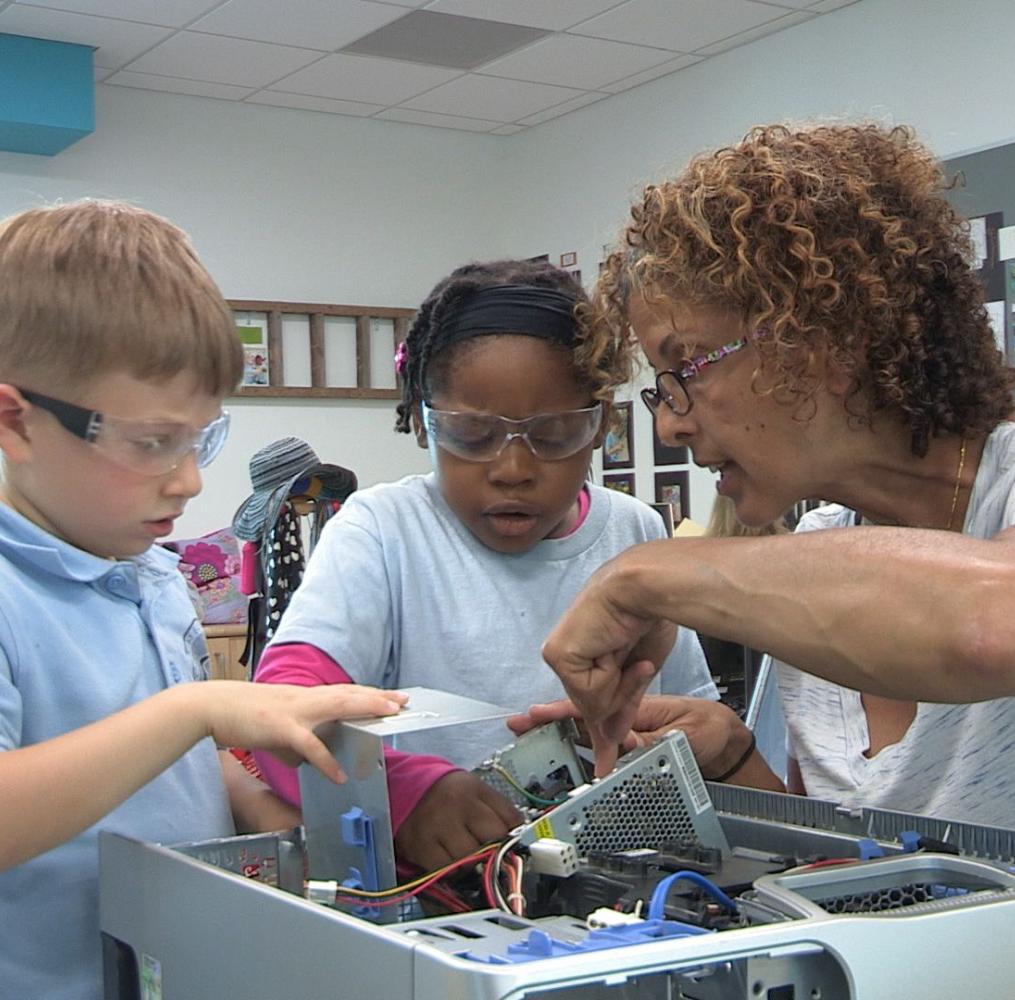 Teacher and elementary students working on a robot project