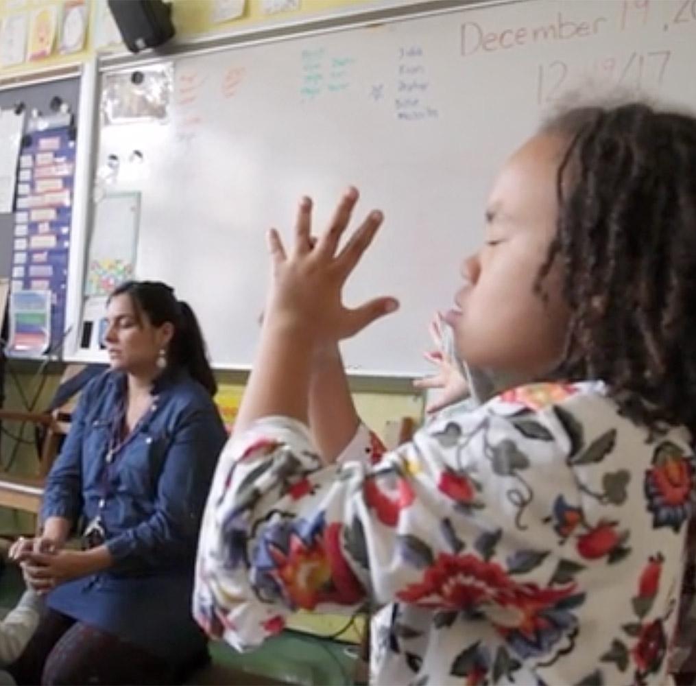 Teacher and elementary students practicing mindfulness techniques