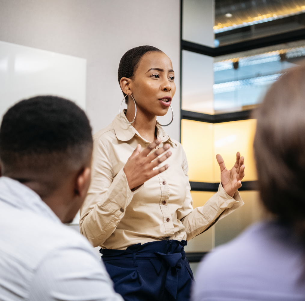 Woman presenting in front of colleagues.