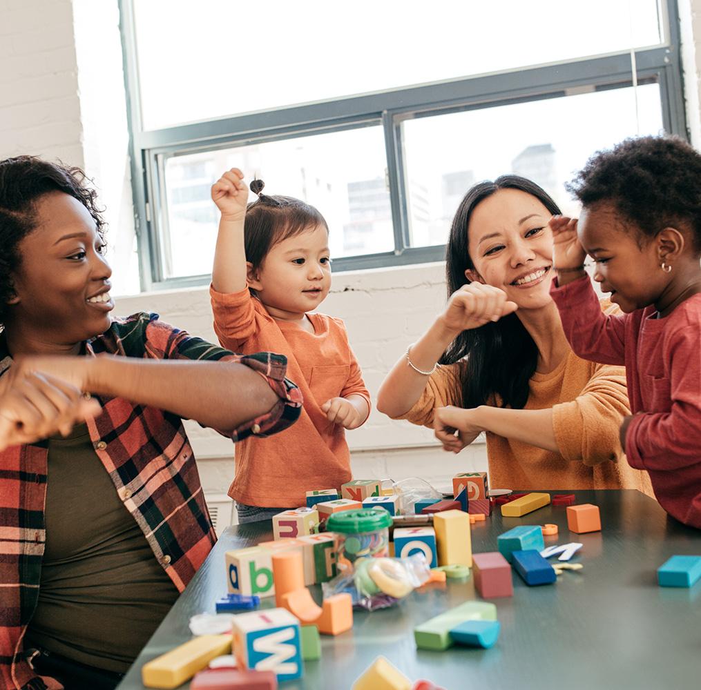 Two pre-school teachers interacting with students.