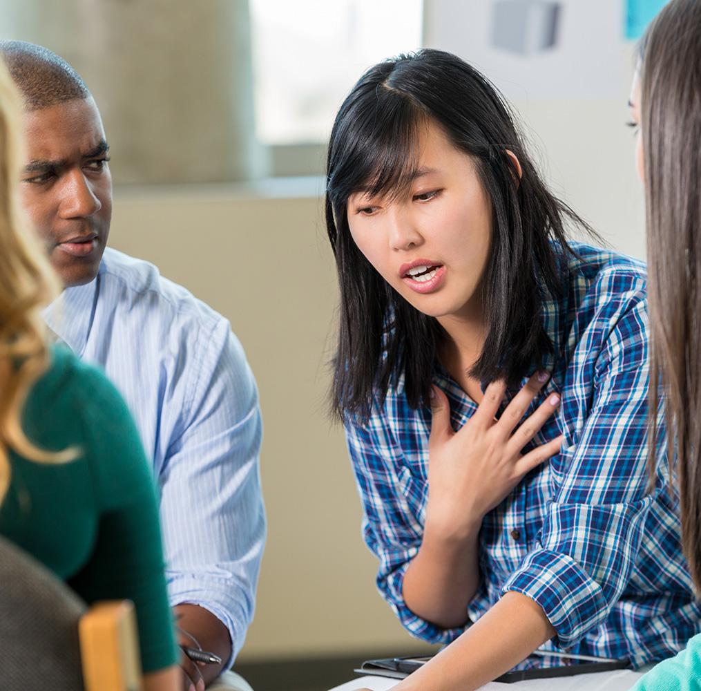 Teenage student having a serious discussion with peers and a counselor.