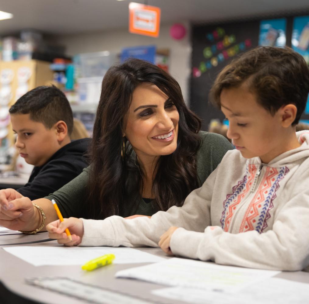 Teacher assisting an elementary student with an assignment