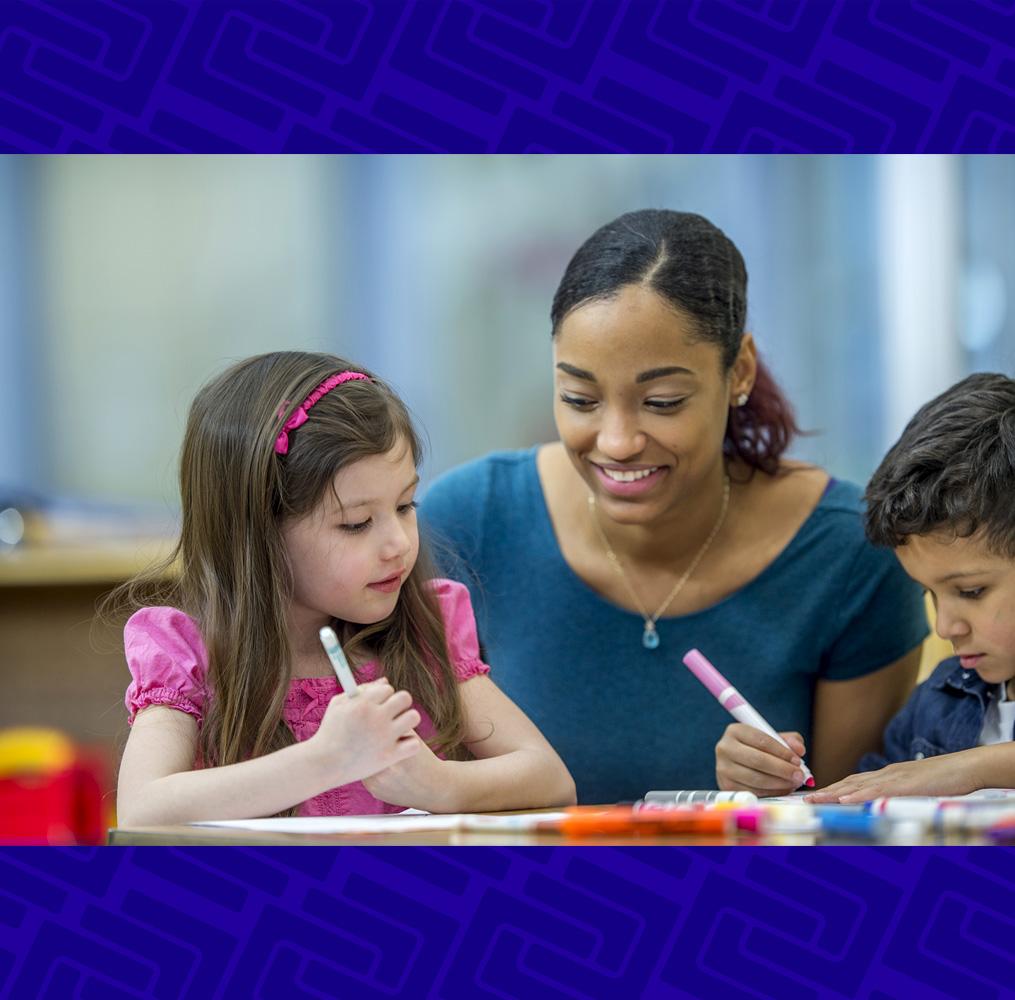 Teacher helping elementary students with an assignment.