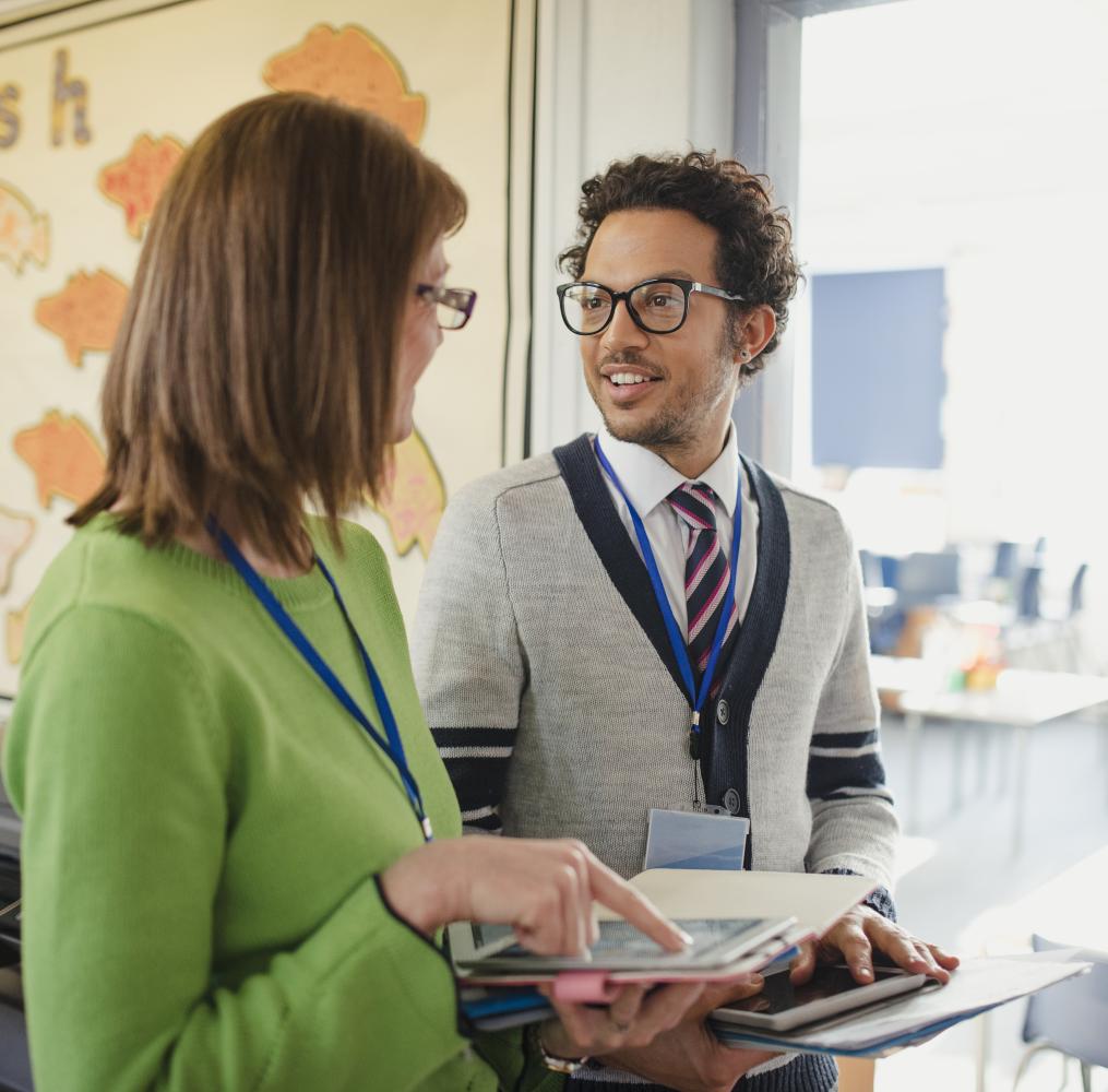 Two teachers talking in a classroom.