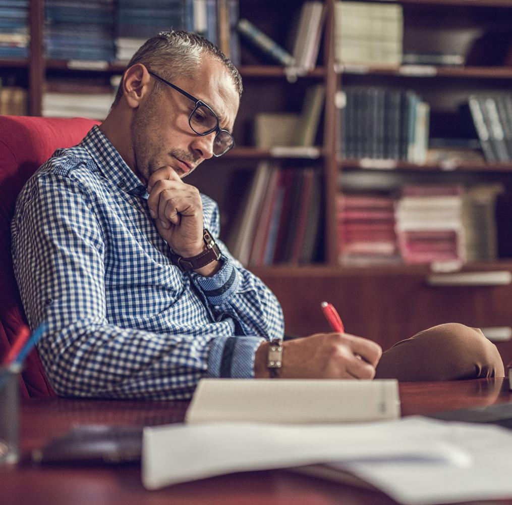 A principal writing at a desk.