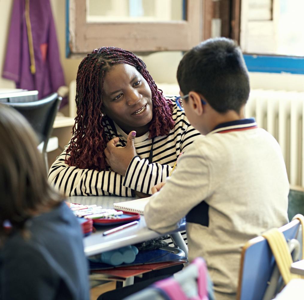 Teacher speaking with an elementary student.