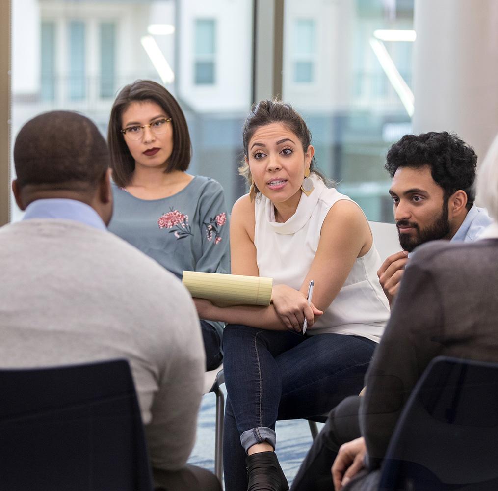 Group of seated adults having a discussion.