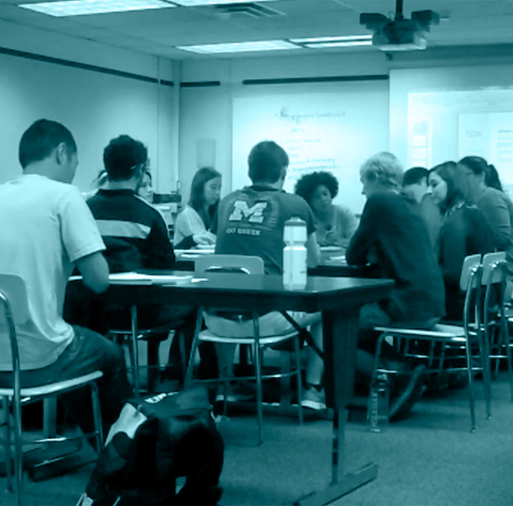 Professor speaking to college students in a classroom.