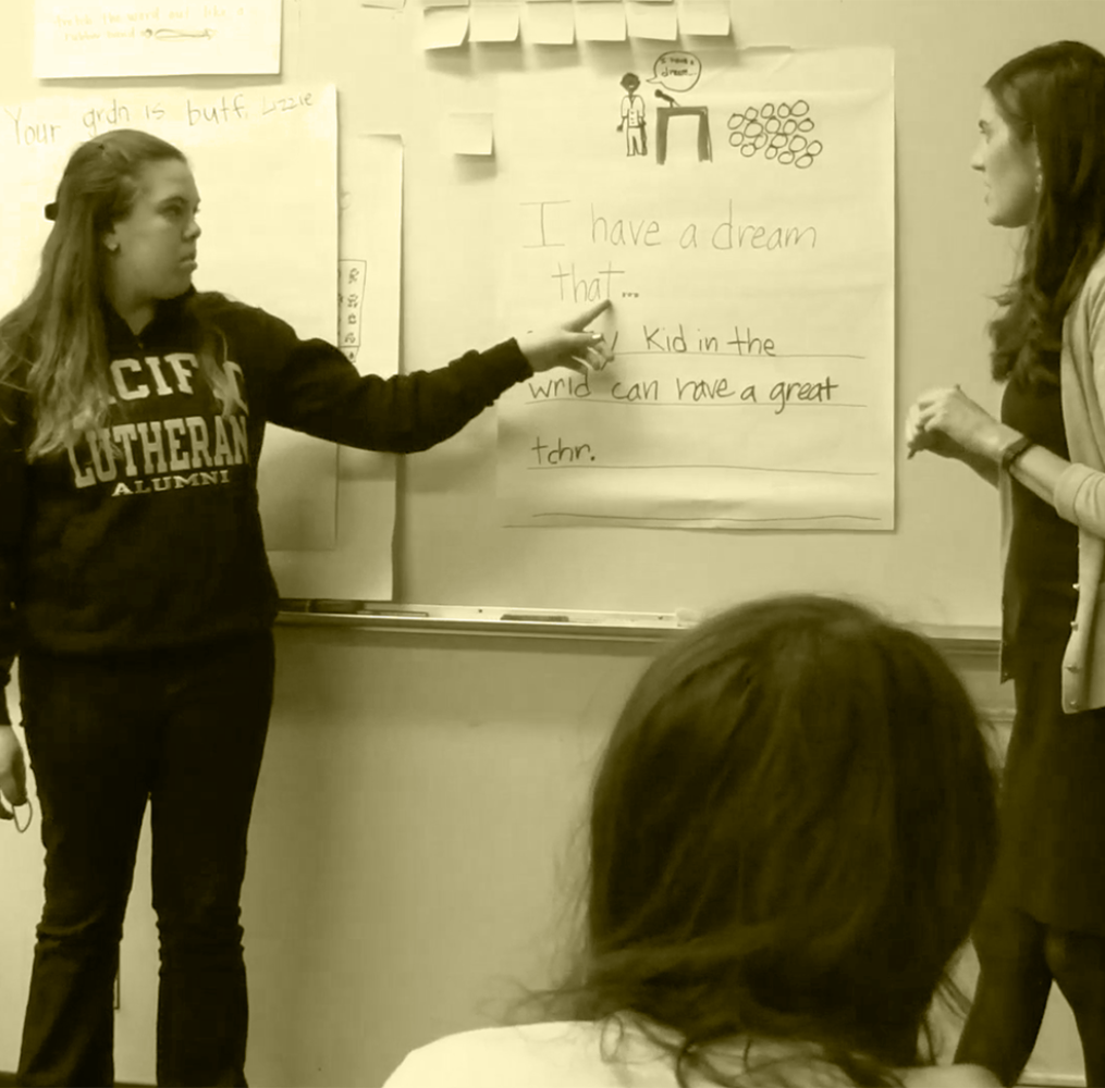 A student teacher presenting in front of a whiteboard.