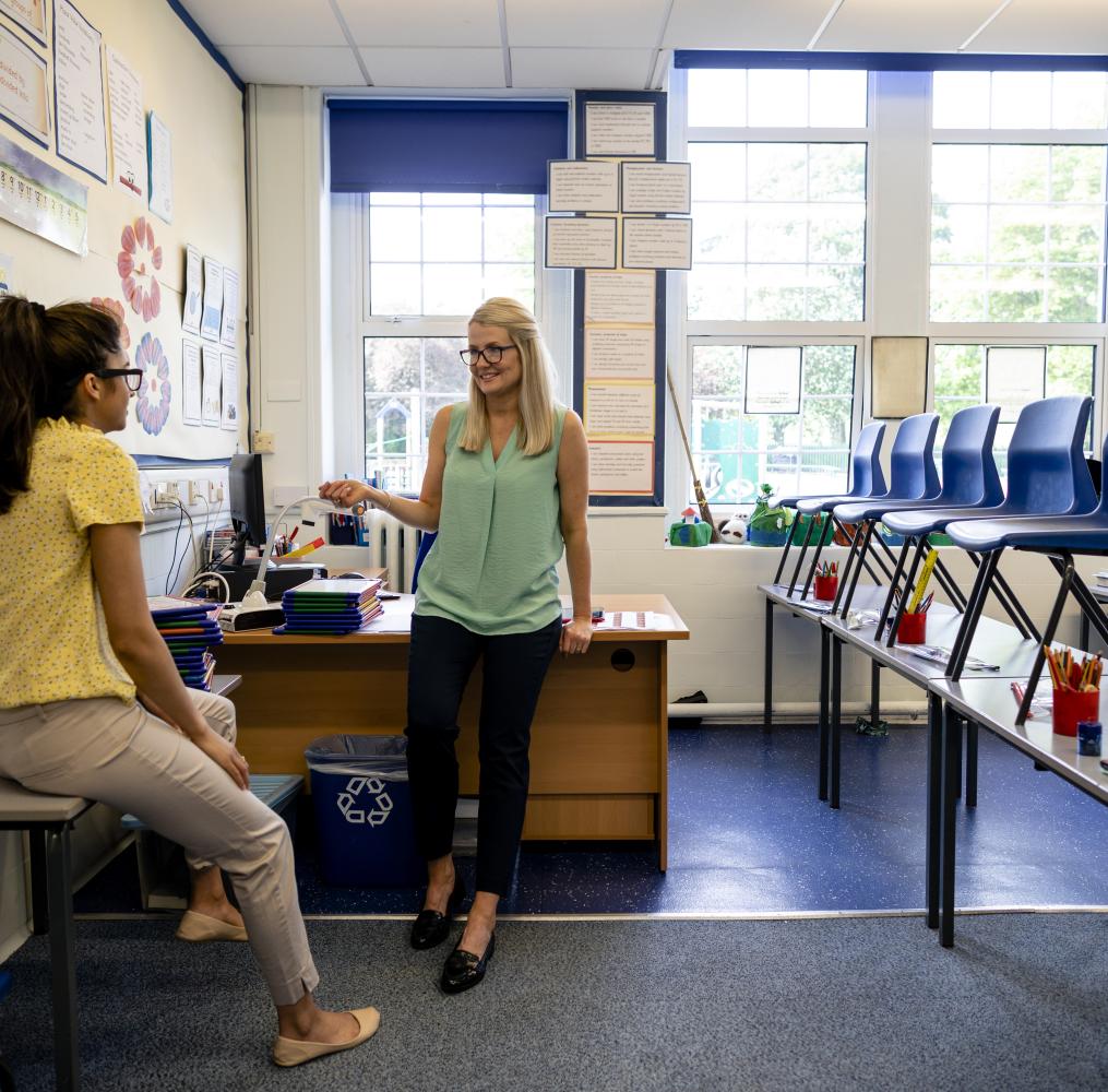 Two educators talking in a classroom.