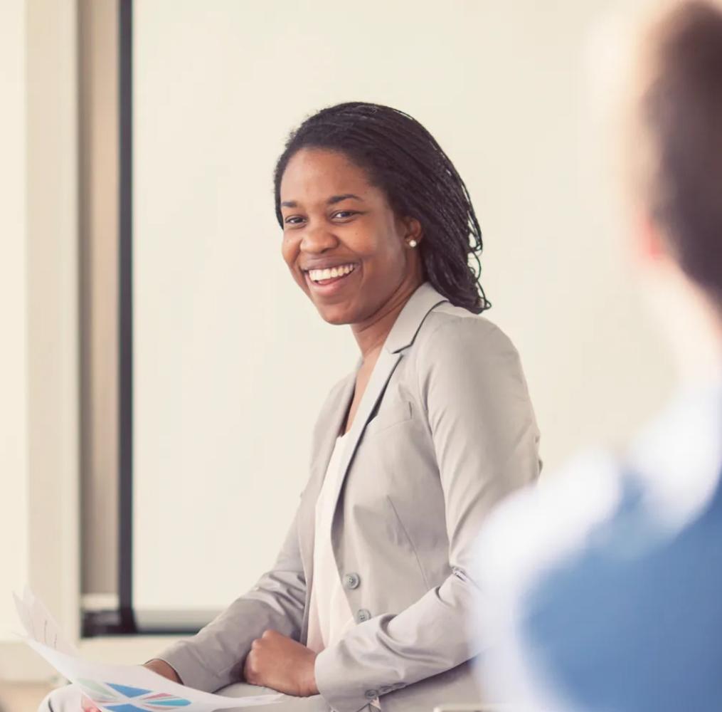 A woman presenting to a group of adults.