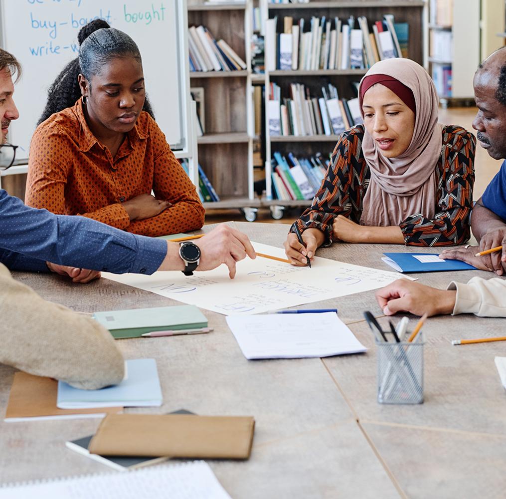 Group of adult students discussing an assignment.