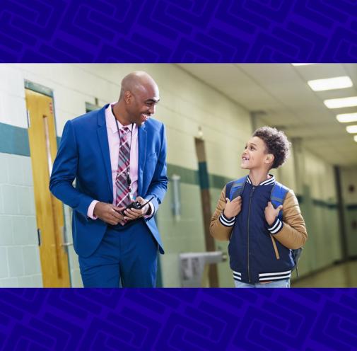 Elementary student walking with principal in school hallway