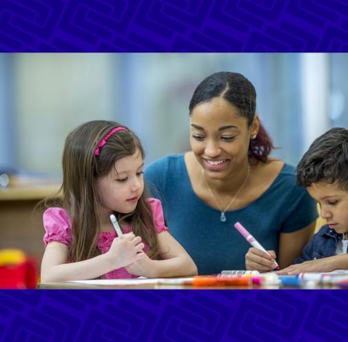 Teacher helping elementary students with an assignment.
