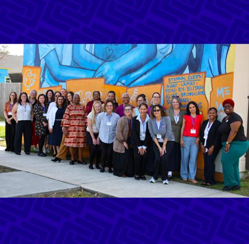 Group of educators in front of an outdoor mural.