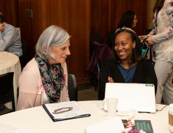 Two people in conversation at convening on educator preparation