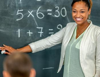 teacher pointing to a blackboard