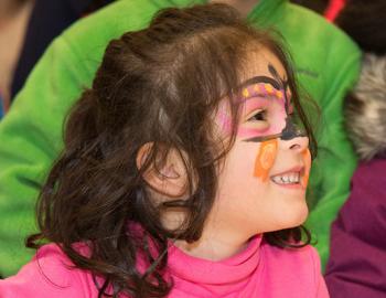 Elementary aged girl with a colorful face painting