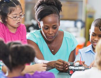 Teacher working at a table with elementary aged students