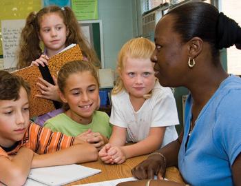 Teacher working at a table with elementary aged students