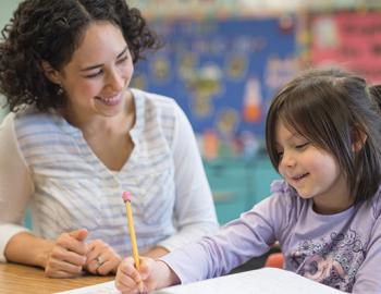 a teacher working with an elementary age girl