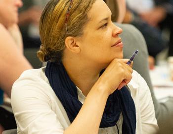 Woman seated and listening to a presentation