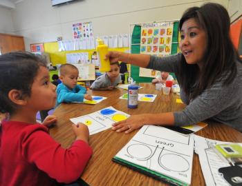 A teacher works with several students at a learning center in Long Beach, California, October 2013