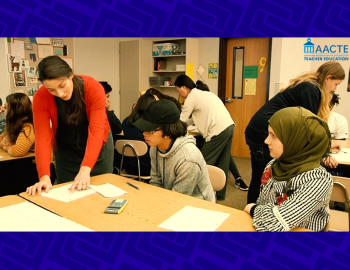 Teacher talking to students at a school desk.