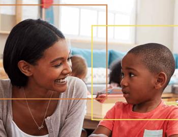 Woman and a boy smiling in a school setting.