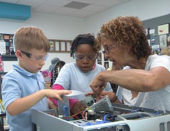 Teacher and elementary students working on a robot project