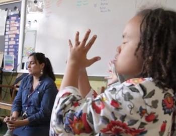 Teacher and elementary students practicing mindfulness techniques