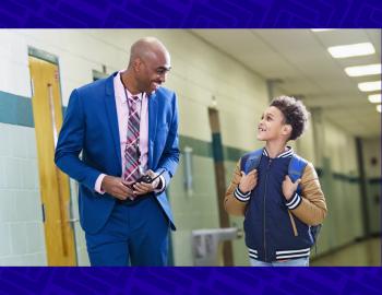 Elementary student walking with principal in school hallway