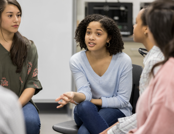 Young adult having a discussions with peers.