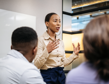 Woman presenting in front of colleagues.