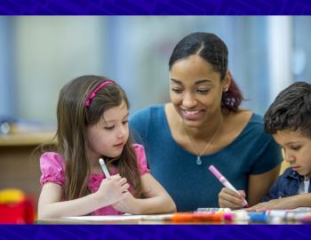 Teacher helping elementary students with an assignment.