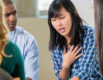 Teenage student having a serious discussion with peers and a counselor.